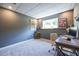 Finished basement used as an office with a gray wall, carpet and a sunny egress window at 1215 Smoke Hill Ln, Hoschton, GA 30548
