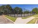 Fenced tennis court with lighting for evening play and well-maintained surroundings at 1215 Smoke Hill Ln, Hoschton, GA 30548