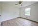 Bedroom featuring clean walls, stylish, light wood-look flooring, window, and modern ceiling fan at 382 Plantation Blvd, Lawrenceville, GA 30046