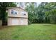 A detached garage featuring a two-story design, a front-facing garage door, and an adjacent side entrance at 382 Plantation Blvd, Lawrenceville, GA 30046