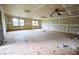 Spacious living room ready for renovation, featuring large windows, and a ceiling fan at 382 Plantation Blvd, Lawrenceville, GA 30046