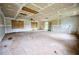 Large living room awaiting renovation, featuring plywood, windows, ceiling fan and entry to the backyard at 382 Plantation Blvd, Lawrenceville, GA 30046