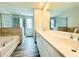 Bathroom featuring double sinks, large mirror, tub and tiled shower at 4495 Buttonwood Ln, Lilburn, GA 30047