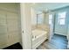 Relaxing bathroom features a soaking tub, glass-enclosed shower, and shelving for storage at 4495 Buttonwood Ln, Lilburn, GA 30047
