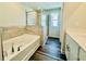 Bright bathroom with a tub, tiled shower, and sleek vanity with drawers at 4495 Buttonwood Ln, Lilburn, GA 30047