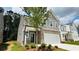 New two-story home with brick and siding exterior, attached garage, and manicured lawn at 4495 Buttonwood Ln, Lilburn, GA 30047