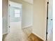 Neutral colored hallway leads to a bedroom with two windows, and a closed door on the right at 4495 Buttonwood Ln, Lilburn, GA 30047