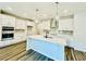 Bright kitchen with white cabinets, stainless appliances, kitchen island, and wood flooring at 4495 Buttonwood Ln, Lilburn, GA 30047