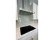 Modern kitchen featuring a sleek black cooktop, stainless steel hood, and gray subway tile backsplash at 4495 Buttonwood Ln, Lilburn, GA 30047