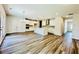 Open kitchen and living room with wood flooring, white cabinets, and kitchen island at 4495 Buttonwood Ln, Lilburn, GA 30047