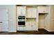 This kitchen has built in stainless steal appliances surrounded by white cabinets and stone backsplash at 4495 Buttonwood Ln, Lilburn, GA 30047