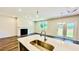 Open kitchen with a bright white island and a view of the living room with a fireplace at 4495 Buttonwood Ln, Lilburn, GA 30047