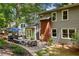 View of backyard patio with outdoor seating, grill, brick chimney, and lush landscaping at 6800 Wright Rd, Atlanta, GA 30328