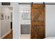 Stylish bathroom with a dark wood sliding barn door, modern vanity, and neutral color palette at 6800 Wright Rd, Atlanta, GA 30328