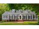 Charming single-Gathering home with gray siding, dormer windows, manicured landscaping, and a brick walkway to the front door at 6800 Wright Rd, Atlanta, GA 30328