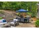 Outdoor patio with a dining table, umbrella, grill, and comfortable seating surrounded by lush greenery at 6800 Wright Rd, Atlanta, GA 30328