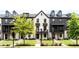 Charming townhomes boast a mix of white brick and gray siding, complemented by well-manicured lawns at 135 Climbing Ivy Cir, Fayetteville, GA 30214