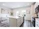 Open concept kitchen with white cabinets, stainless steel appliances, and an island with bar stools at 135 Climbing Ivy Cir, Fayetteville, GA 30214