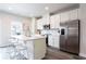 Modern kitchen featuring white cabinets, stainless steel appliances, and an island with counter seating at 135 Climbing Ivy Cir, Fayetteville, GA 30214