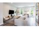 Bright and airy living room with modern furniture, hardwood floors, and natural light from the balcony doors at 135 Climbing Ivy Cir, Fayetteville, GA 30214
