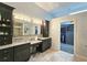 Bathroom featuring double sink vanity, decorative mirror, and doorway to walk-in closet at 1885 Dayron Trce, Marietta, GA 30062