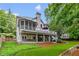 Backyard of the home with large deck, patio, and lush green lawn at 220 Foxley Way, Roswell, GA 30075