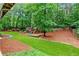 Well-maintained backyard with lush lawn, playground, and mature trees, offering a serene outdoor space at 220 Foxley Way, Roswell, GA 30075