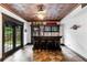 Home bar featuring tile flooring, decorative ceiling, cabinetry, barstools, and access to the outdoors at 220 Foxley Way, Roswell, GA 30075
