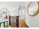 Upstairs hallway features hardwood floors, a chandelier, and an ornate gold framed mirror at 220 Foxley Way, Roswell, GA 30075