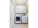 Well-lit laundry room with modern washer and dryer units, white cabinets, and stylish tile flooring at 220 Foxley Way, Roswell, GA 30075