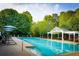 Sparkling community pool with lounge chairs, umbrellas, and a covered seating area for relaxation at 220 Foxley Way, Roswell, GA 30075