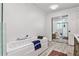 Bright bathroom featuring a soaking tub, glass enclosed shower, and mirrored closet doors at 2244 Deer Ridge Dr, Tucker, GA 30087