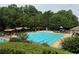 Large community pool surrounded by lush trees, cabanas, and lounge chairs at 2244 Deer Ridge Dr, Tucker, GA 30087