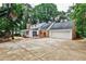Rear exterior of home, with patio, attached garage, and basketball court at 2244 Deer Ridge Dr, Tucker, GA 30087