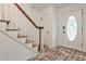 Bright foyer boasts brick floors, staircase with wooden banister, and a front door with an oval window at 2244 Deer Ridge Dr, Tucker, GA 30087