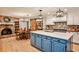 Beautiful open kitchen features a large island with a blue base, brick backsplash, and fireplace at 2244 Deer Ridge Dr, Tucker, GA 30087