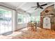Bright sunroom features terra cotta tile flooring, brick accent wall, and large windows offering serene views at 2244 Deer Ridge Dr, Tucker, GA 30087