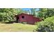 Exterior view of a vintage outbuilding with weathered wood and a simple window in a grassy yard at 294 A Donald Rd, Canton, GA 30114