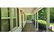 Charming covered front porch with black railing and hanging lights with a wooden swing at 294 A Donald Rd, Canton, GA 30114