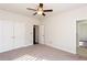 Bedroom with ceiling fan, neutral carpet, and entry to ensuite bathroom at 5015 Montes Ln, Cumming, GA 30040