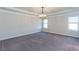 Spacious bedroom with neutral carpet, a trey ceiling, decorative chandelier, and natural light from windows at 5015 Montes Ln, Cumming, GA 30040