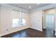 Bright bedroom featuring hardwood floors, neutral walls, and large window with modern shades at 5015 Montes Ln, Cumming, GA 30040