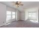 Spacious bedroom with neutral carpet, ceiling fan, natural light from two windows, and sloped ceiling at 5015 Montes Ln, Cumming, GA 30040
