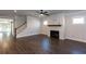 Spacious living room with hardwood floors, fireplace, and staircase at 5015 Montes Ln, Cumming, GA 30040