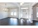 Light-filled living room featuring a modern chandelier, crown molding, and hardwood flooring at 5015 Montes Ln, Cumming, GA 30040