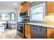 Well-lit kitchen with wooden cabinets, stainless steel appliances, granite countertops and mosaic tile backsplash at 588 Oakdale Ne Rd, Atlanta, GA 30307