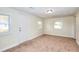 Finished basement area featuring two windows, a door leading outside, and neutral carpet at 6316 Rockland Rd, Lithonia, GA 30038