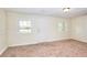 Neutral colored basement space features carpeted floors, one door, and natural light from two windows at 6316 Rockland Rd, Lithonia, GA 30038