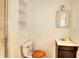 Compact bathroom with a toilet, vanity, mirror, and enclosed shower with glass door at 6316 Rockland Rd, Lithonia, GA 30038