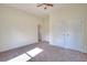 Cozy bedroom with neutral walls, carpet, double closet doors and access to another room at 6316 Rockland Rd, Lithonia, GA 30038